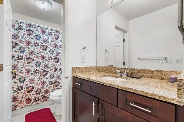 a bathroom with a granite countertop sink and a mirror