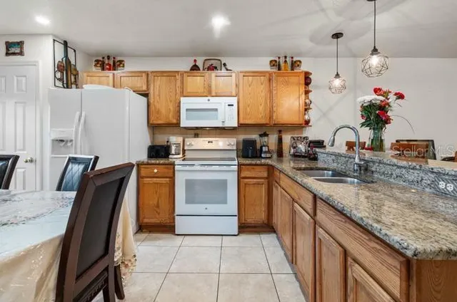 a kitchen with granite countertop a sink stainless steel appliances and cabinets