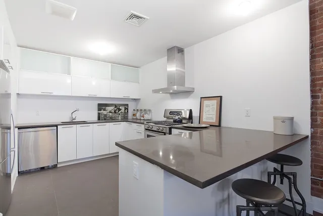 a kitchen with a sink a stove and chairs
