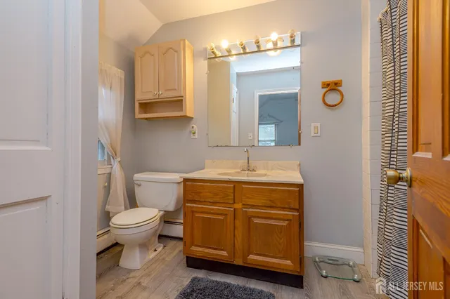 a bathroom with a granite countertop toilet sink and mirror