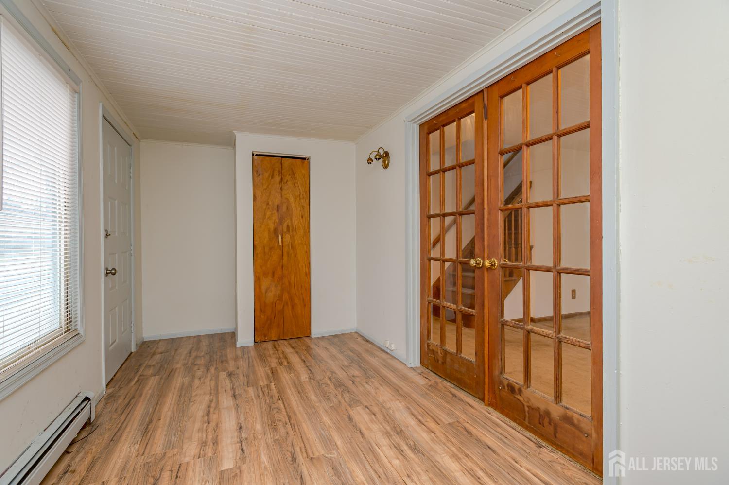 205 Main Street Spotswood, NJ 08884 - Photo 5 of 22 an empty room with wooden floor and a window