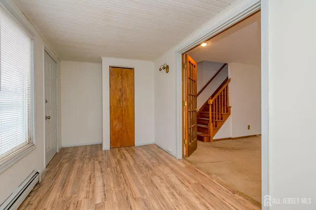 a view of a hallway with wooden floor and stairs
