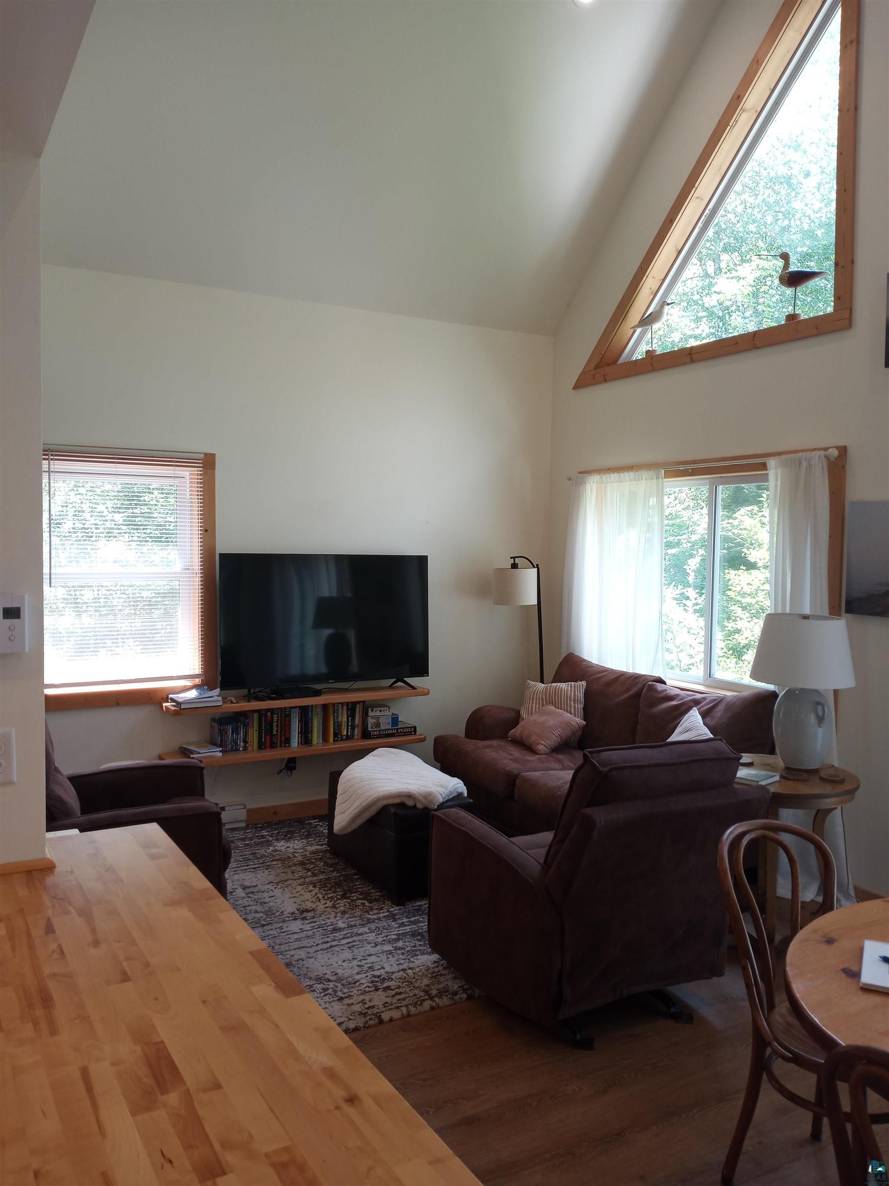 88525 Romans Point Road Herbster, WI 54844 - Photo 9 of 14 Living room with hardwood / wood-style floors and high vaulted ceiling