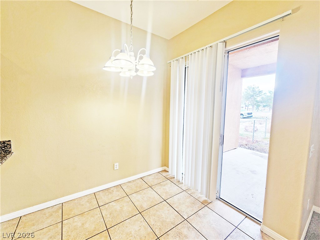 1421 Star Road, Unit 2 Pahrump, NV 89048 - Photo 8 of 33 Unfurnished dining area featuring baseboards, light tile patterned floors, and a chandelier