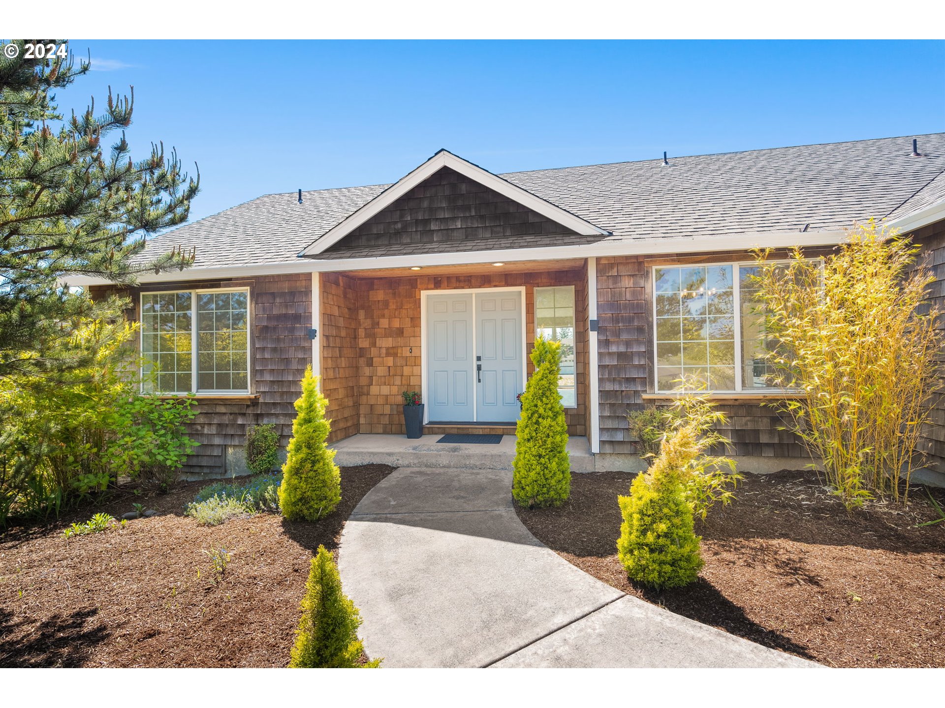 9980 Pine Ridge Drive Nehalem, OR 97131 - Photo 2 of 27 a front view of a house with garden