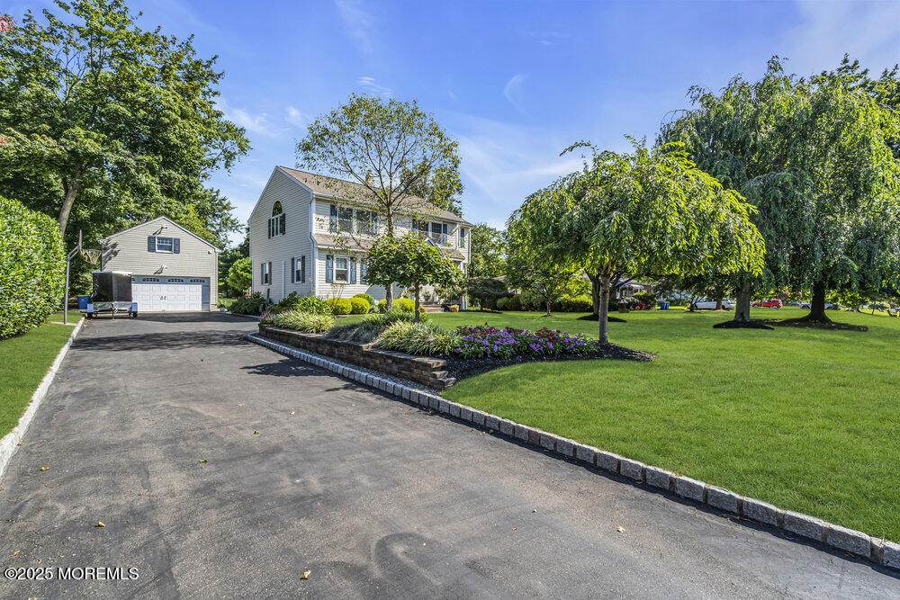a front view of a house with a yard and trees