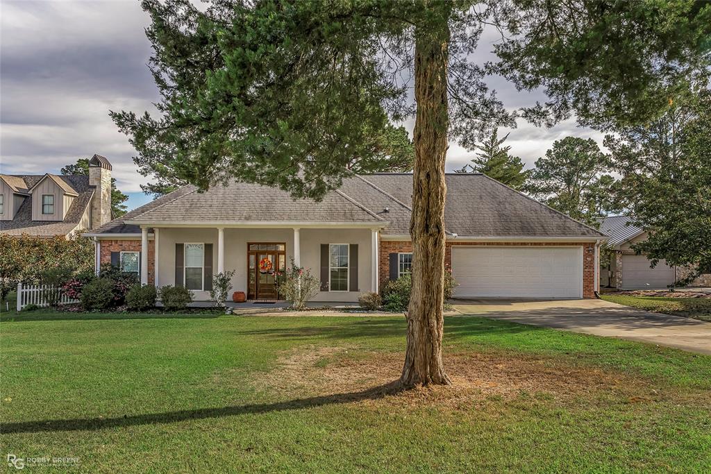 a front view of a house with a yard and trees