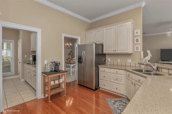 a kitchen with stainless steel appliances kitchen island granite countertop a refrigerator and cabinets