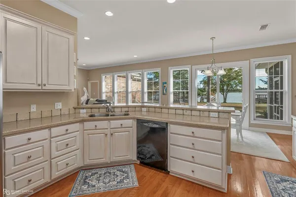 a kitchen with granite countertop white cabinets and white stainless steel appliances