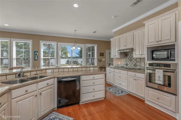 a kitchen with granite countertop white cabinets and white appliances