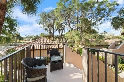 a balcony with wooden floor and outdoor seating