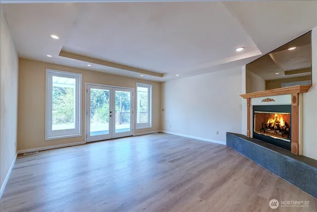 a view of an empty room with a fireplace and a window