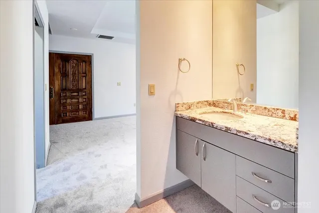 a bathroom with a granite countertop sink and a mirror