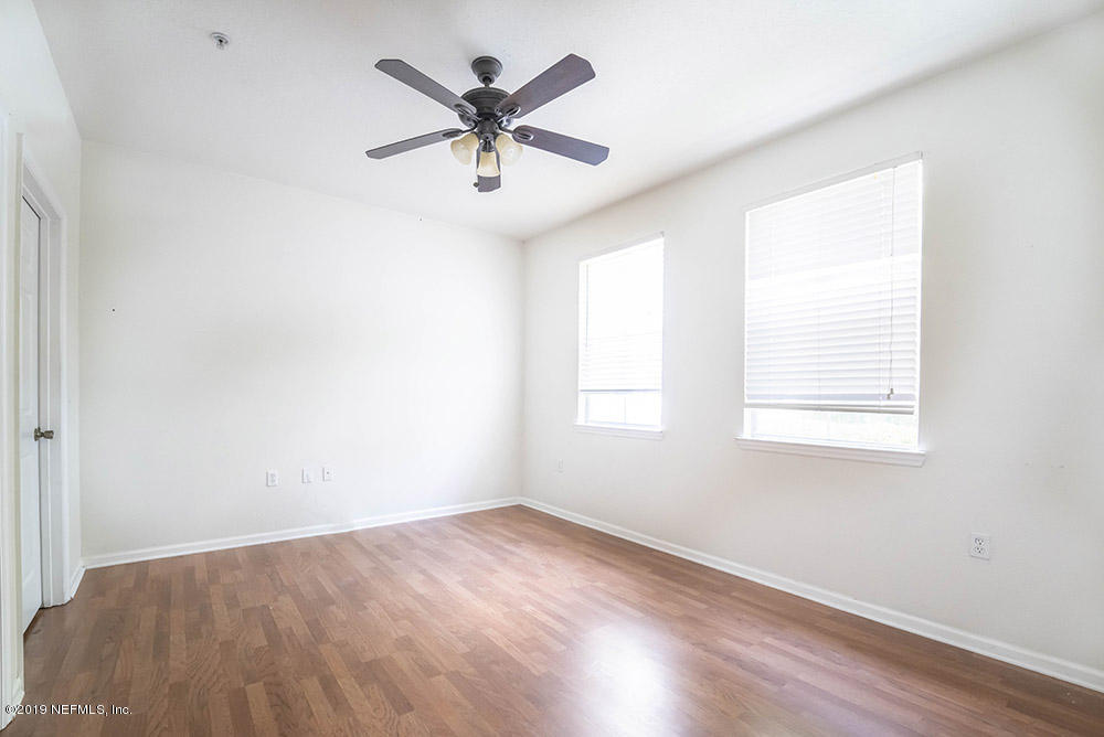 8550 Touchton Road, Unit 218 Jacksonville, FL 32216 - Photo 11 of 29 an empty room with wooden floor and windows