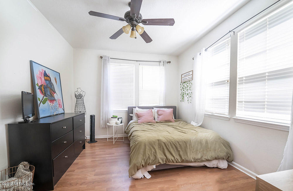 8550 Touchton Road, Unit 218 Jacksonville, FL 32216 - Photo 12 of 29 a bedroom with a bed and a flat tv screen on dresser