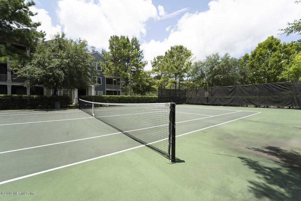 8550 Touchton Road, Unit 218 Jacksonville, FL 32216 - Photo 27 of 29 a view of a tennis court with trees in the background