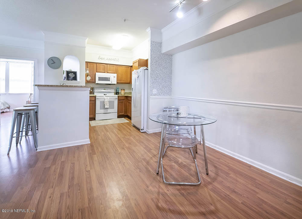 8550 Touchton Road, Unit 218 Jacksonville, FL 32216 - Photo 3 of 29 a kitchen with wooden floors and white stainless steel appliances