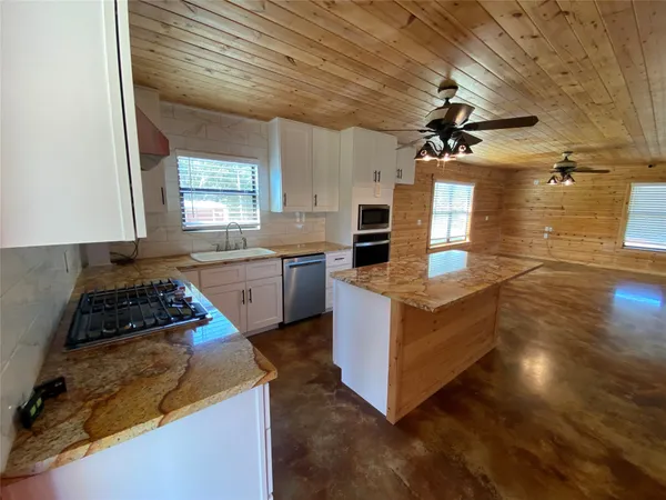 a kitchen with granite countertop a stove and a sink