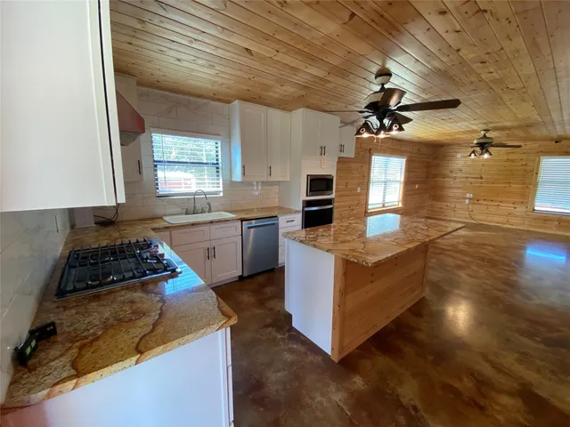 a kitchen with granite countertop a stove and a sink