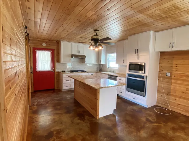a kitchen with stainless steel appliances granite countertop a stove a sink and a refrigerator