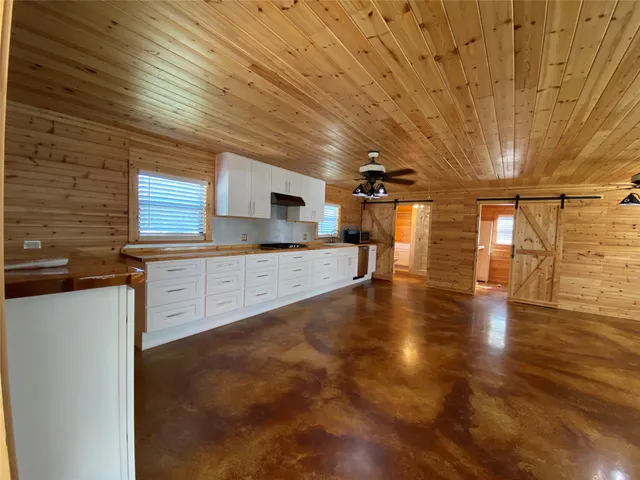 a large kitchen with stainless steel appliances granite countertop a sink and cabinets