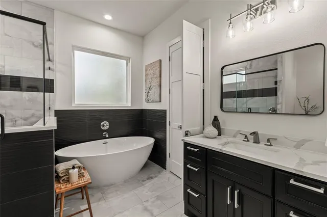 a spacious bathroom with a double vanity sink mirror and bathtub