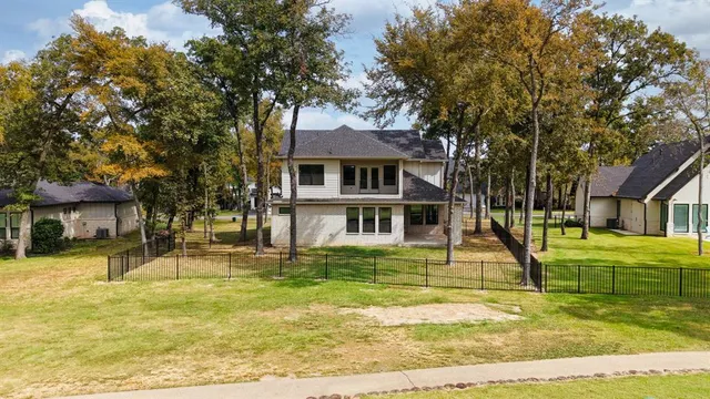 a view of a house with a big yard and large trees