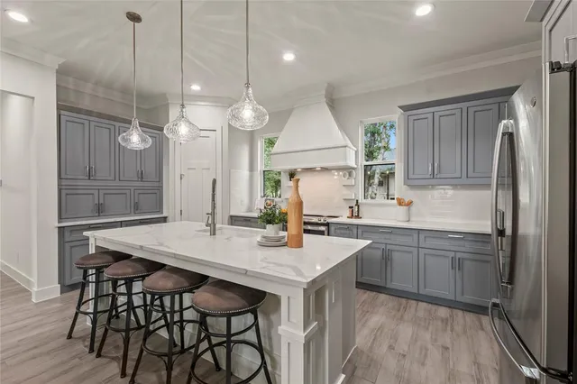 a kitchen with a table chairs refrigerator and wooden floor