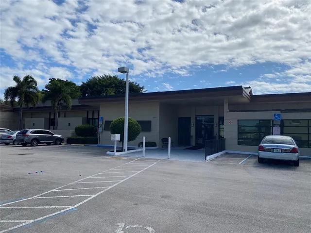a couple of table and chairs in front of house