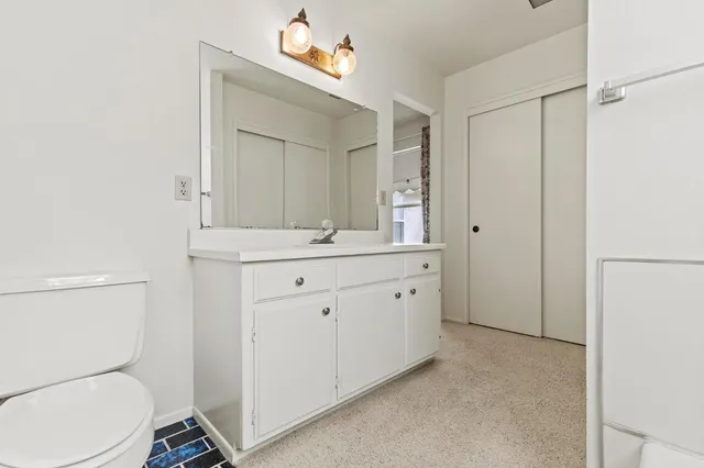 a bathroom with a toilet a sink a mirror and a shower