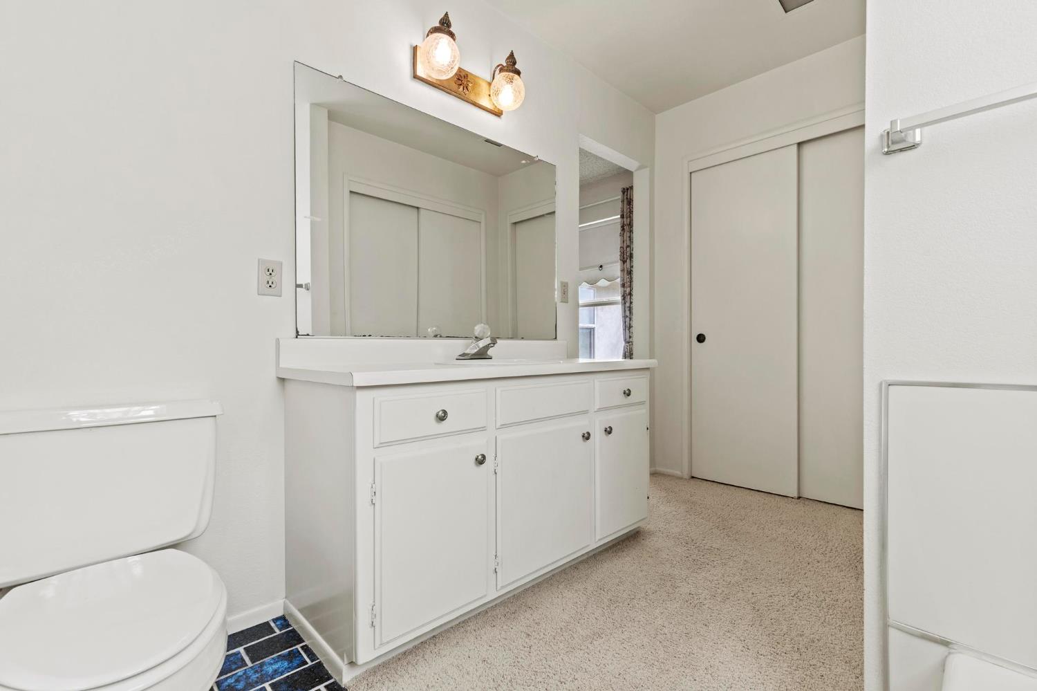 225 Elm Street Maxwell, CA 95955 - Photo 15 of 50 a bathroom with a toilet a sink a mirror and a shower