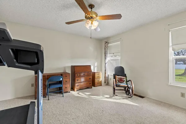 a living room with furniture a ceiling fan and a window