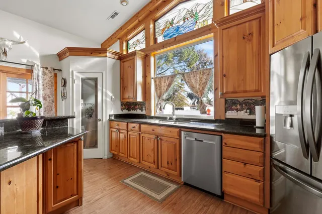 a kitchen with stainless steel appliances granite countertop a refrigerator and a sink