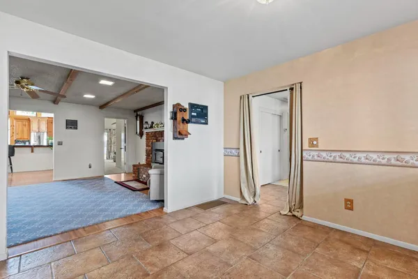a view of a livingroom with wooden floor and kitchen space