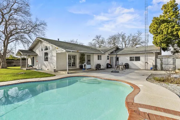 a front view of a house with swimming pool having outdoor seating