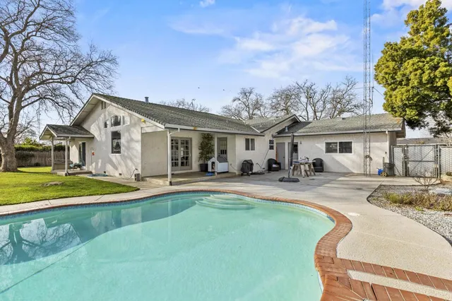 a front view of a house with swimming pool having outdoor seating