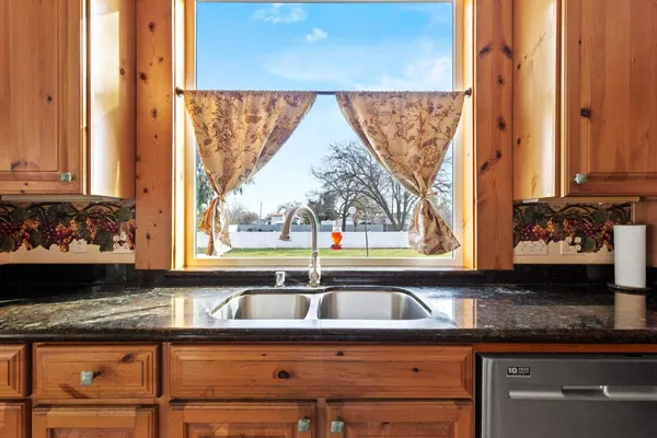 a view of a kitchen with granite countertop sink and cabinets