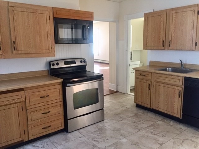 51 May Street Worcester, MA 01610 - Photo 6 of 23 a kitchen with cabinets stainless steel appliances and wooden cabinets