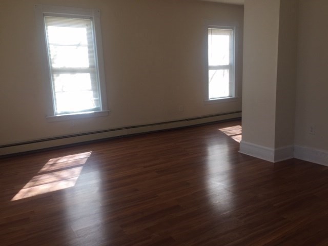 51 May Street Worcester, MA 01610 - Photo 10 of 23 an empty room with wooden floor and windows