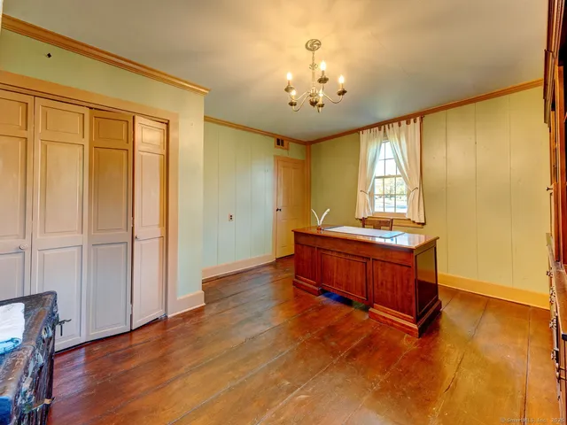 a spacious bedroom with a bed and a chandelier