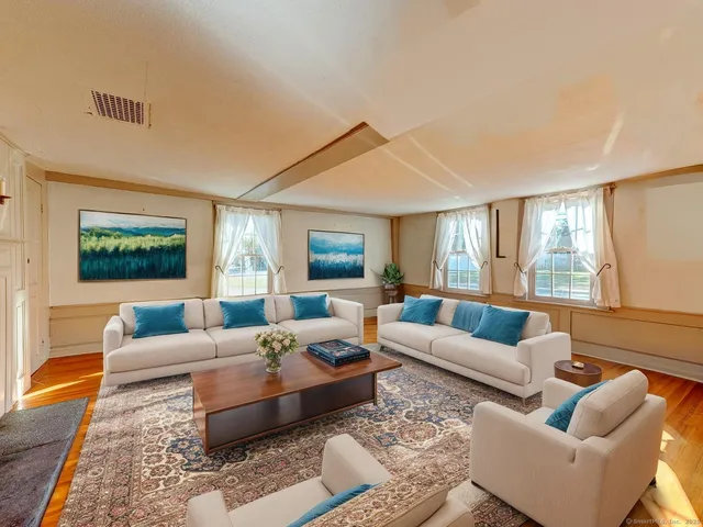 a living room with furniture wooden floor and a large window