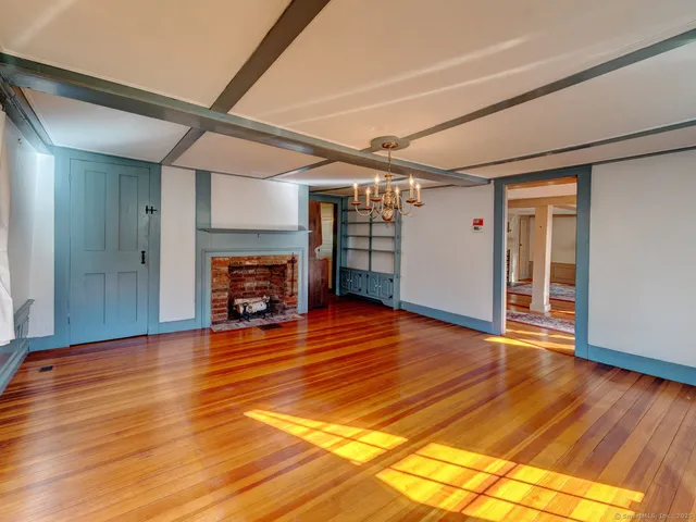 a view of empty room with wooden floor and fireplace