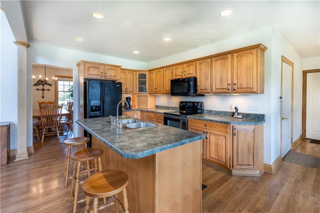 290 Hellein School Road Acme, PA 15610 - Photo 8 of 25 a kitchen with stainless steel appliances granite countertop a stove top oven a sink dishwasher a refrigerator and a dining table with wooden floor