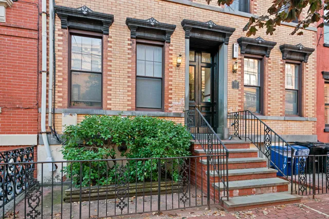a view of a house with large windows and plants