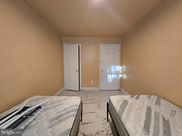 a bedroom with a bed and a lamp on the dresser