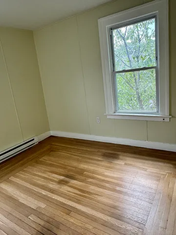a view of a room with wooden floor and a window