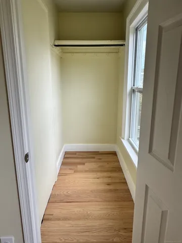 a view of a room with wooden floor and a window