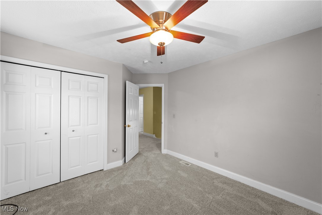 1802 Spring Road Cleveland, OH 44109 - Photo 20 of 40 Unfurnished bedroom with ceiling fan, a closet, and light colored carpet