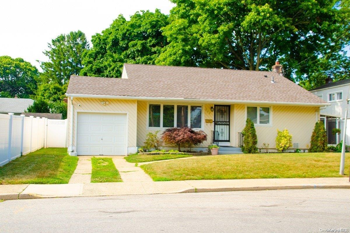 a view of house that has a bunch of plants and large trees