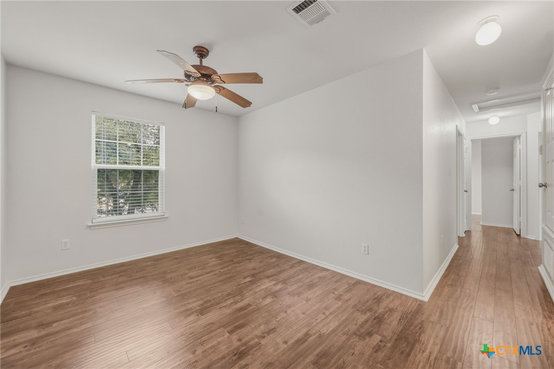 109 Comal Cove Elgin, TX 78621 - Photo 14 of 34 wooden floor in an empty room with a window